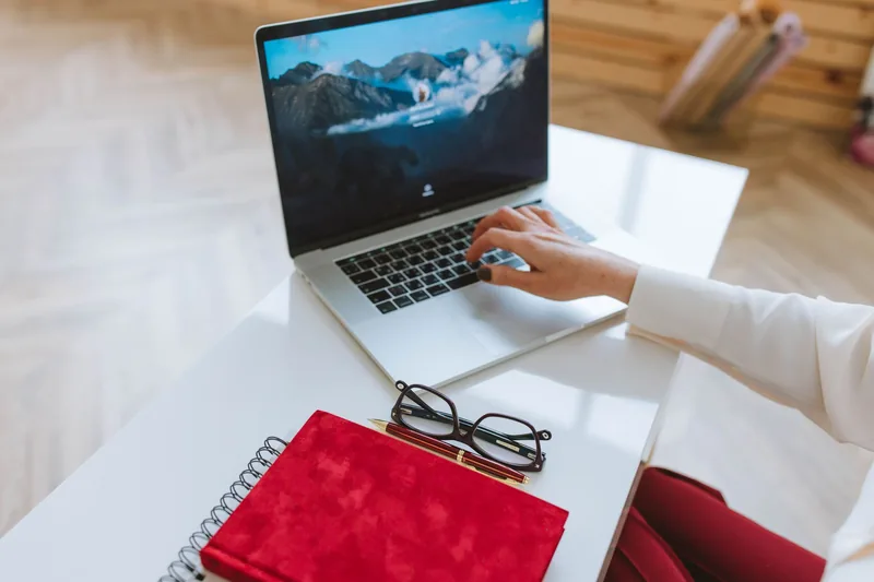 Person drafting content on a laptop at a modern desk