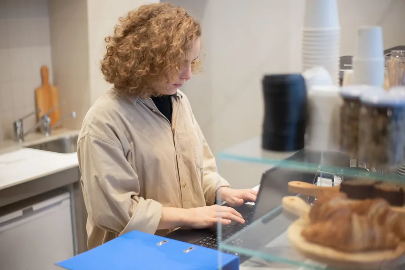 Small business owner working on a laptop at a shop counter