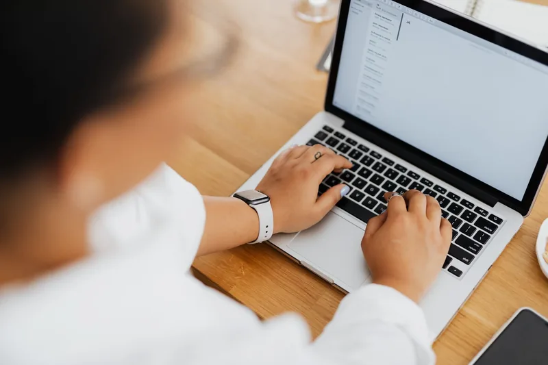 Small-business owner writing an automated email flow on a laptop