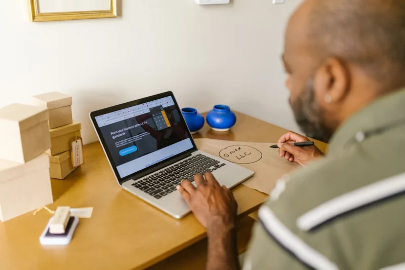 Small-business owner reviewing website pricing on a laptop