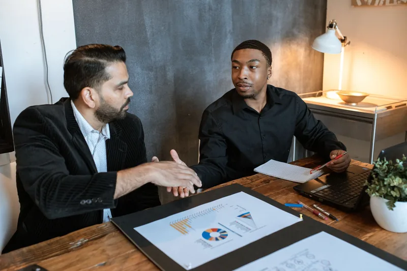 Small-business owner meeting with an SEO agency representative to review a proposal