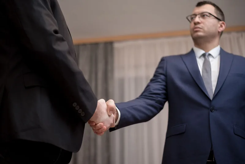 Business owner shaking hands with an SEO agency partner after agreeing to work together