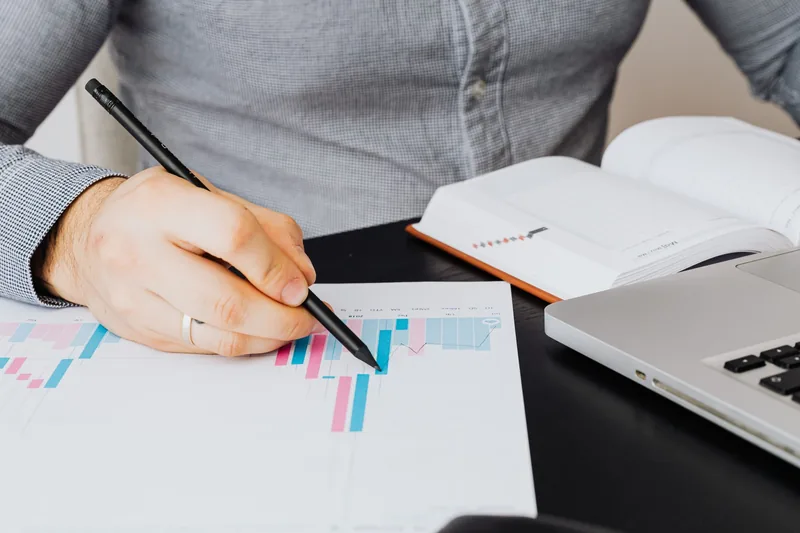 Marketer reviewing an SEO performance report and analytics chart at a desk
