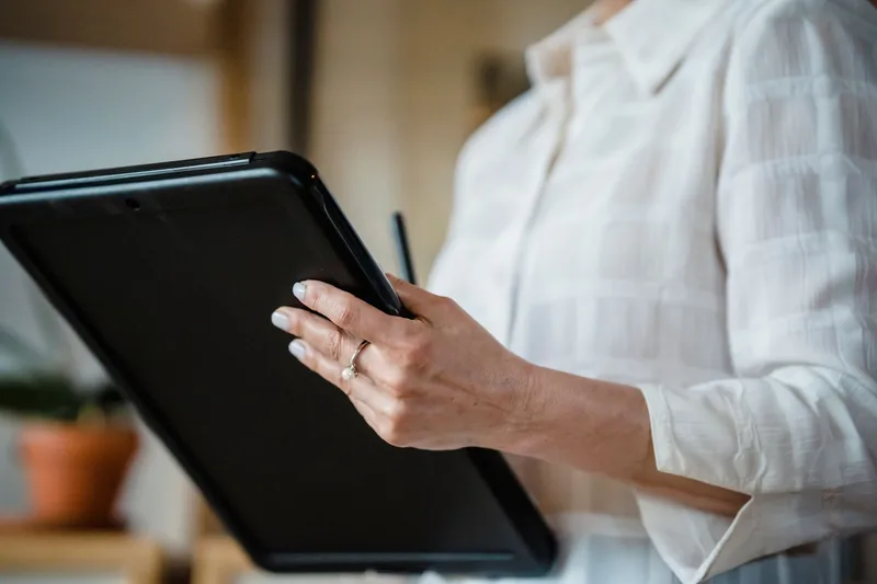 Business owner holding a tablet and reviewing a one-page checklist