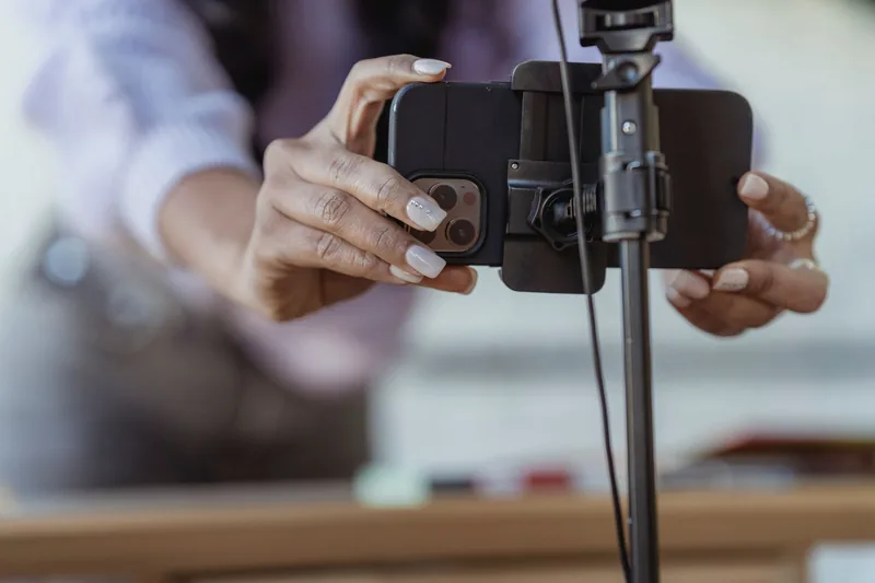 Business owner mounting a smartphone on a tripod to record a short video