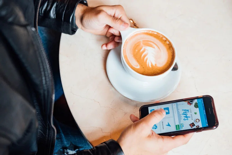 Small-business customer checking a business on social media over coffee