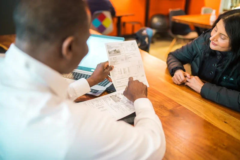 Consultant walking a business owner through a plan at a table